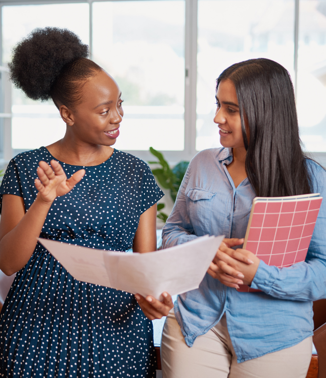 Black professional women working and smilling at each other